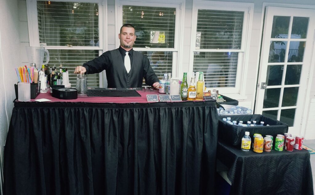 Male bartender serving drinks behind the bar